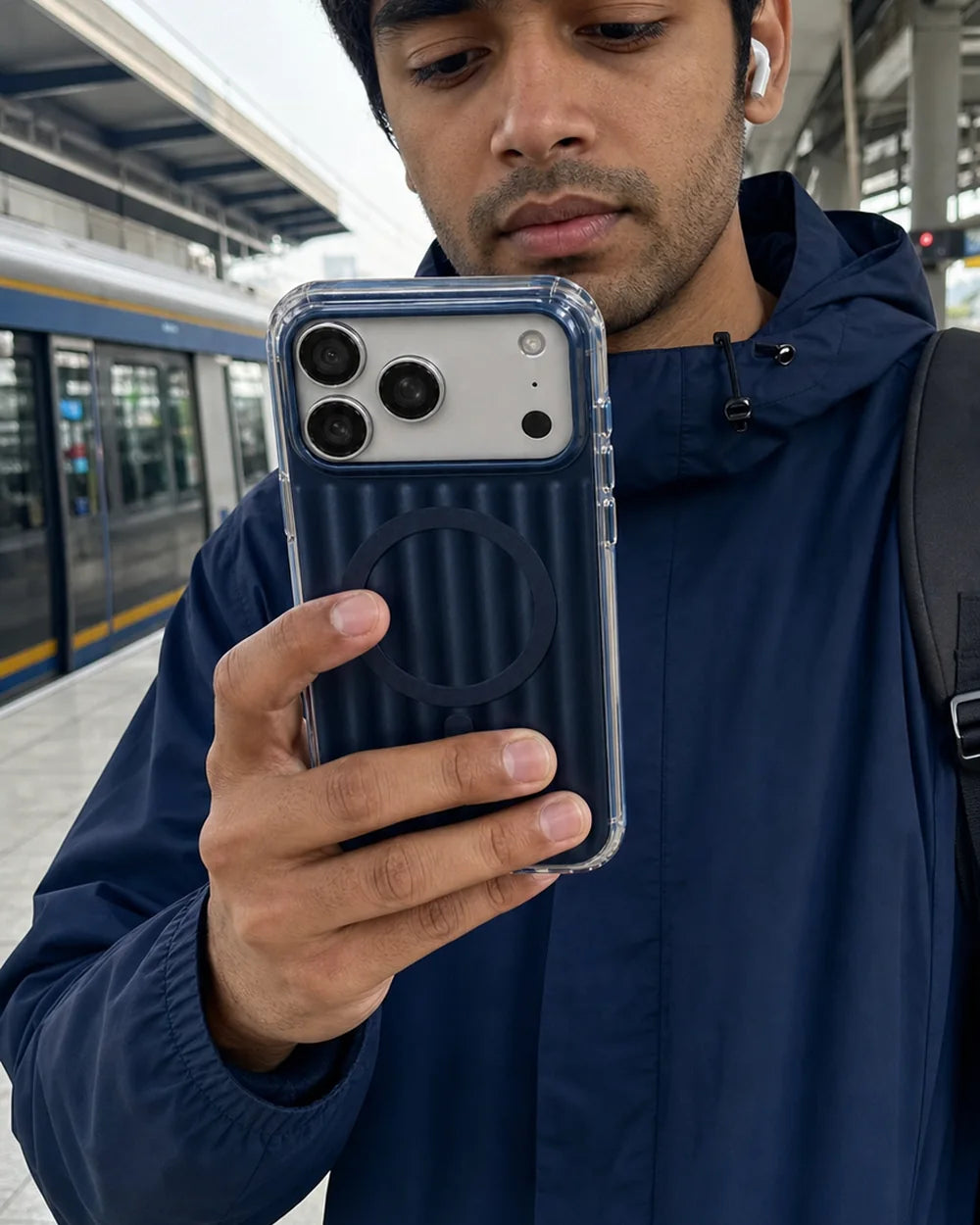 Commuter holding a deep-blue Ribbed MagSafe CaseBear iPhone 17 Pro Max case