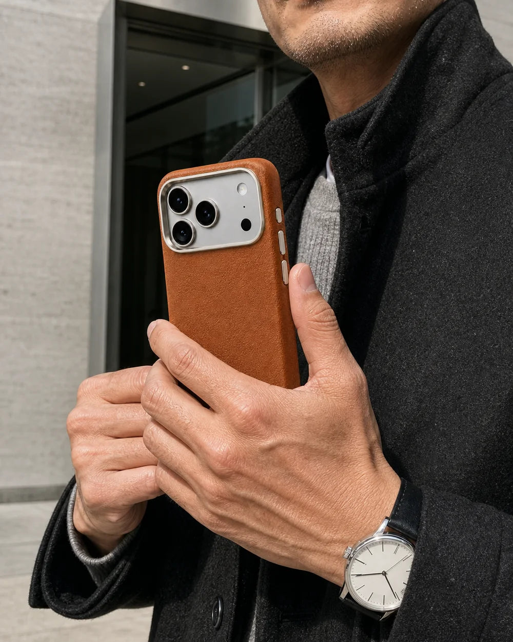 Man holding a classic-brown Leather CaseBear iPhone 17 Pro Max case outside a gallery